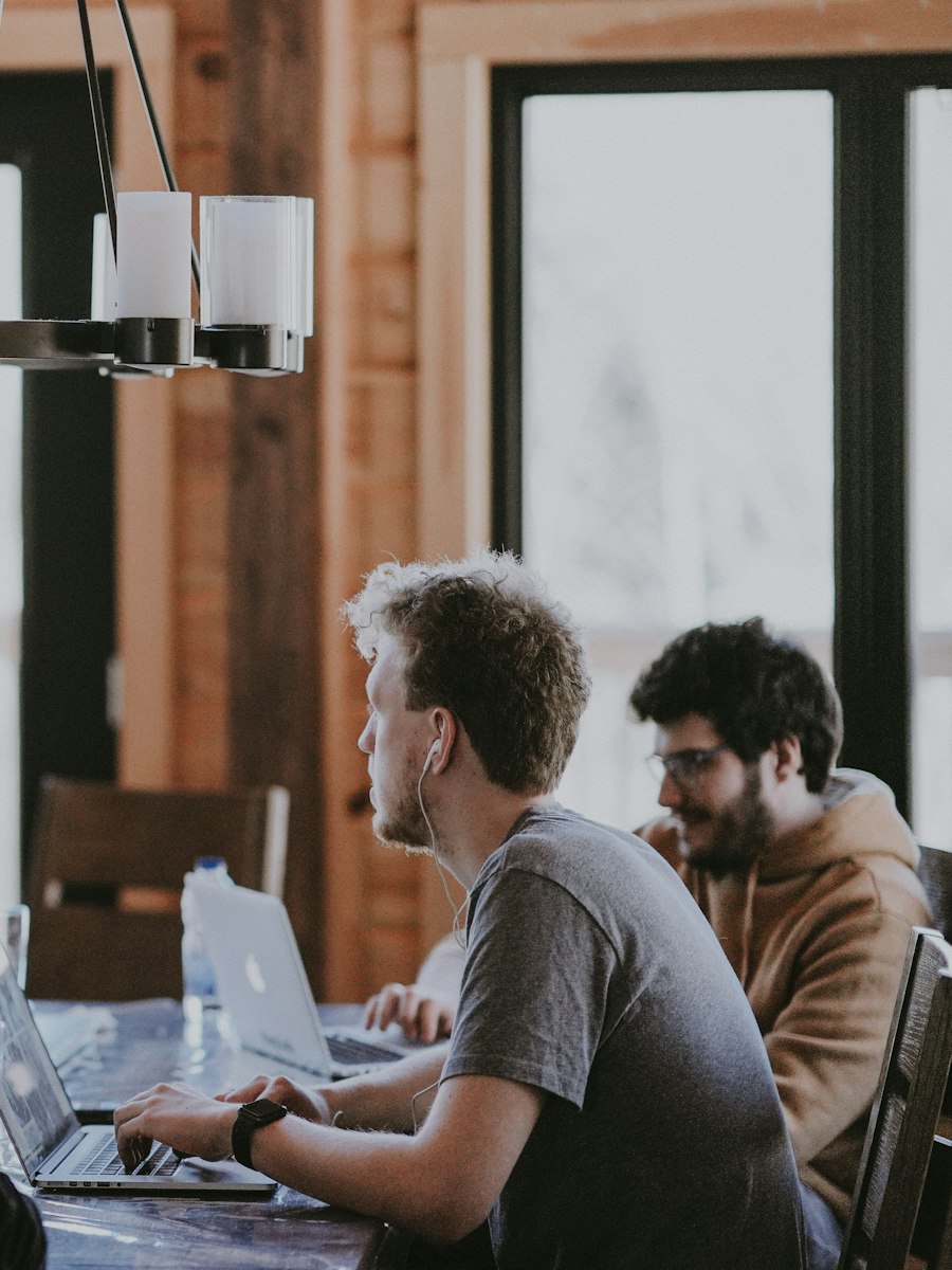 A team working on laptops around a table in a stylish meeting room